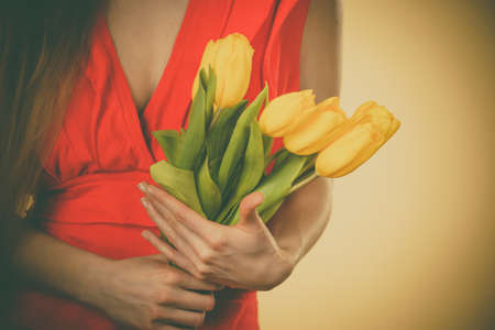 International women day, eight march. Woman hands with yellow tulips. Mothers day dating conceptの写真素材
