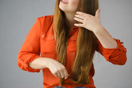 Teenage woman combing her long brown hair showing beautiful hairdo and non split ends.