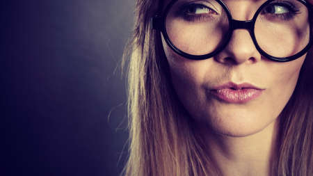 Intellectual expressions, being focused concept. Closeup of attractive woman wearing big eyeglasses thinking face expressionの写真素材