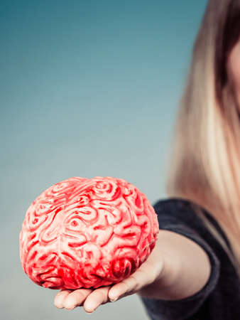 Woman hand holding brain. Having something on mind, thinking of solution idea concept.の写真素材