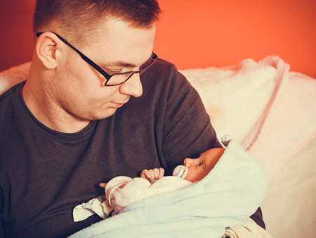 Parenting and love concept. Father holding and taking care of little newborn babyの写真素材