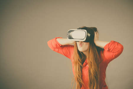 Young emotional woman wearing virtual reality goggles headset, vr box. Connection, technology, new...