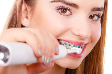 Dentist and orthodontist concept. Young woman smiling cleaning and brushing teeth with blue braces...
