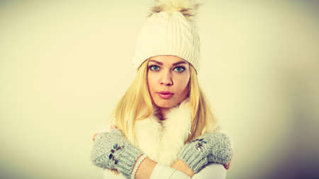Winter fashion. Young blonde woman wearing fashionable wintertime clothes white fur scarf, woolen...