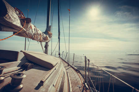 Yachting on sail boat during sunny summer weather on calm blue sea water. Sporty transportation conept.の写真素材