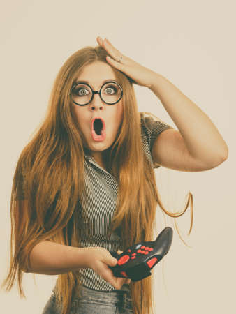 Young adult woman playing on the video console holding pad being very into game. Gaming gamers...