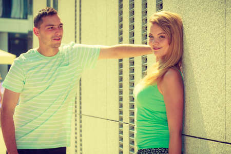 Flirt, love and passion concept. Man flirting with attractive blone girl on city street.の写真素材