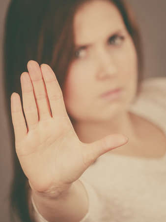 Angry apodicticity woman showing stop sign gesture with open hand, denying something,