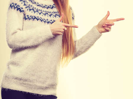 Winter fashion, outfit ideas concept. Woman legs in black leggings trousers and grey furry jumper pointing right.の写真素材