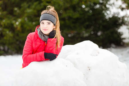 Outdoor recreation concept. Woman wearing warm sportswear playing on snow during winter time.の写真素材