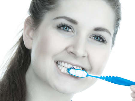Woman brushing cleaning teeth close up. Funny girl with toothbrush. Oral hygiene. Toned imageの写真素材