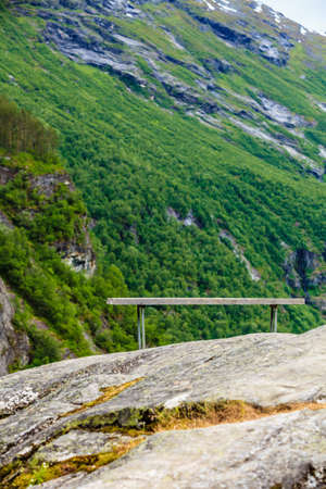 Tourism vacation and travel. Serene mountains landscape with rest place lonely bench, Norway Europe.の写真素材