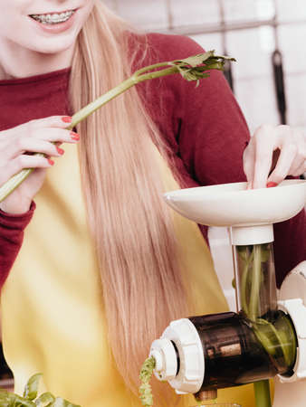 Drinks good for health, diet breakfast concept. Young woman in kitchen making green healthy...