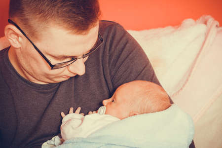 Parenting and love concept. Father holding and taking care of little newborn baby