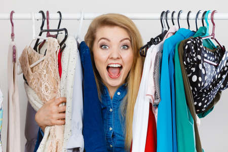 Happy young woman during shopping time picking clothes for perfect fashionable outfit.