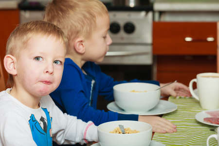 Morning routine in family, healthy diet for children concept. Two boys, kids eating breakfast together.の写真素材