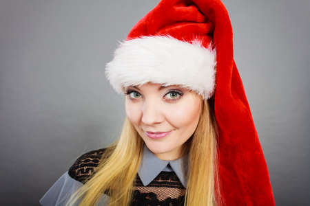 Xmas, seasonal clothing, winter christmas concept. Happy woman wearing Santa Claus helper hatの写真素材