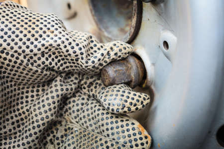 Mechanic fixing, man wearing gloves changing and repair old car tire wheel rim.の写真素材