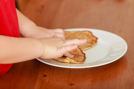 Morning routine in family, healthy diet for children concept. Little boy preparing pancakes for breaktfastの写真素材