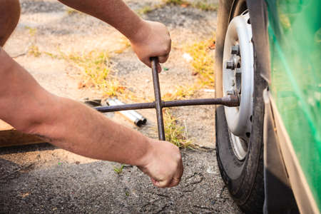 Mechanic fixing, changing and repair old car tire with rim socket wrenchの写真素材