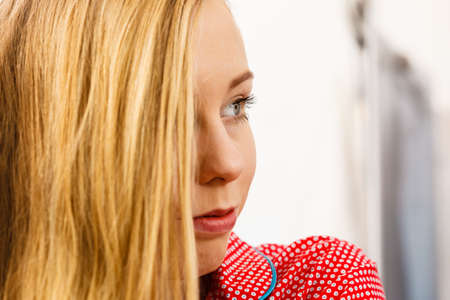 Closeup portrait of attractive young blonde woman looking at something, indoor shot.の写真素材