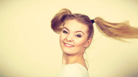 Education, teenage adolescence, happiness concept. Happy blonde teenager student girl with ponytailsの写真素材