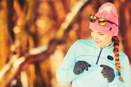 Fit girl in winter park. Exercising among snow and nature. Health fitness safety concept. の写真素材