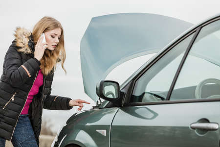 Accident and breakdowns with auto concept. Broken down car, blonde woman having problem, calling to...