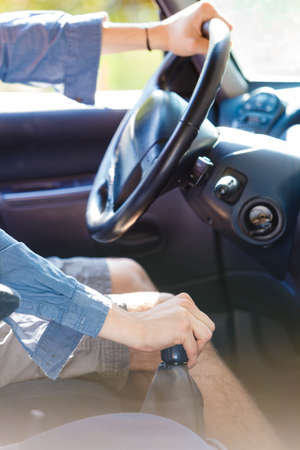 Auto equipment, male driver concept. Man hands on steering wheel, driving car changing gearの写真素材