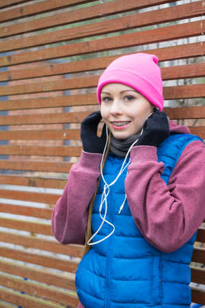 Outdoor sport exercises, sporty outfit ideas. Woman wearing warm sportswear relaxing after...