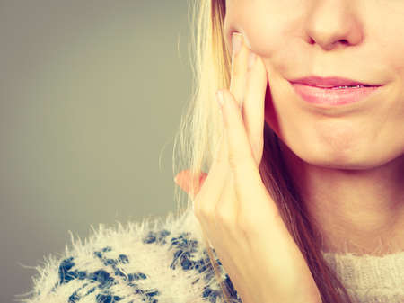 Disease, illness problem concept. Woman having toothache touching her cheek, feeling bad after...