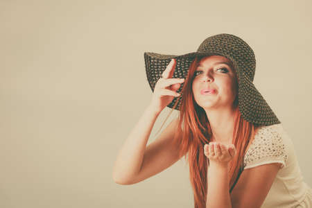 Summertime outfit accessories concept. Happy redhead woman wearing big black sun hat.の写真素材