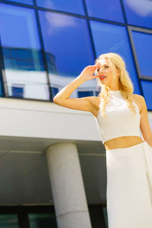 Elegant fashionable fashion female model. Woman in city waiting for someone looking in distance.の写真素材