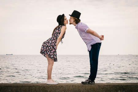 Vintage funny retro couple, man and woman enjoying their romantic date outside wearing fedora hats.の写真素材