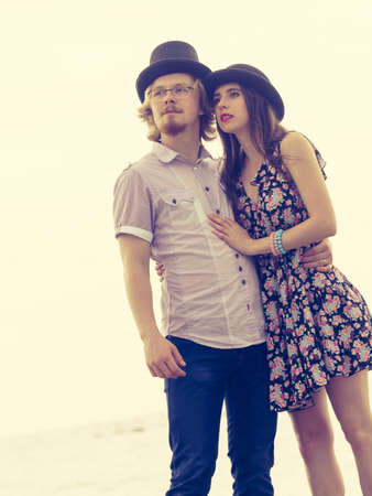 Vintage funny retro couple, man and woman enjoying their romantic date outside wearing fedora hats...