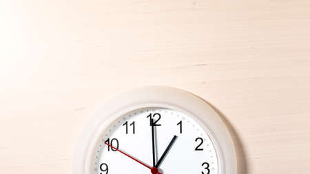 Clock hanging on wall ticking showing one hour