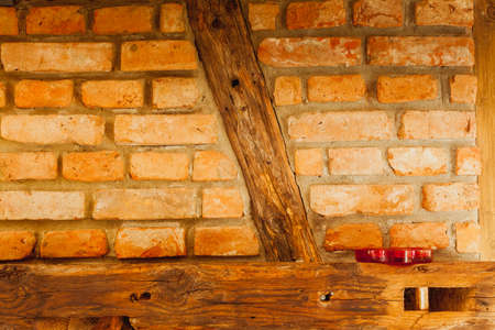 Textures and close up detailed patterns concept. Red brick wall with wooden piecesの写真素材