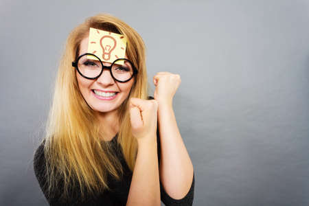 Intellectual expressions, being focused concept. Woman wearing weird nerd eyeglasses having light bulb mark on forehead thinking about something, having great idea or solutionの写真素材