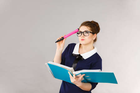 Happy positive accountant business woman holding binder with documents, intensive thinking finding...