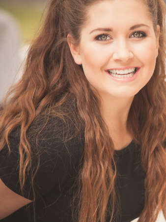 Happy teen woman enjoying her leisure time. Female having long brown hair posing with big smile