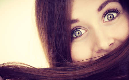 Haircare and hairstyling concept. Woman having face covered with her dark brown hair.の写真素材