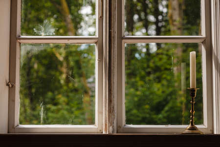 Old vintage objects, wood concept. Old vintage window and vertical candle in candlestickの写真素材