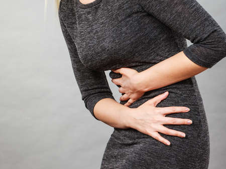 Woman having strong stomach ache. Syndroms of indigestion pregnancy. Female suffer on belly pain,...
