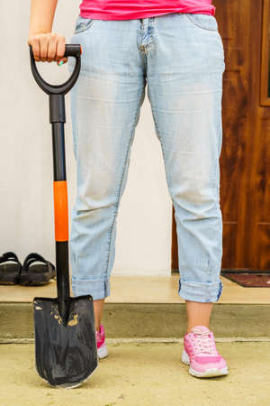 Woman outdoor holding garden work tool, black shovel. Agricultural equipment essentials concept.の写真素材