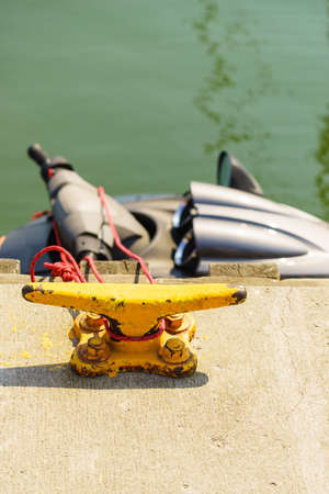 Yellow cleat for ships and boats in marina jetty pier. Yachting and sailing equipment objects concept.の写真素材