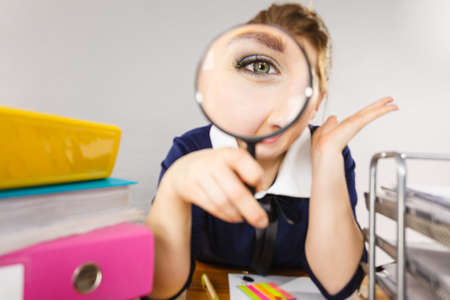 Funny woman office worker secretary with magnifier loupe, magnifying glass.の写真素材