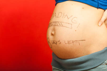 Parenthood, waiting for baby concept. Pregnant woman big belly with loading drawingの写真素材