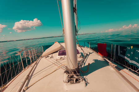 Detailed close up of down side of sail mast on boat during sea cruise. Yachting, sailing objects...