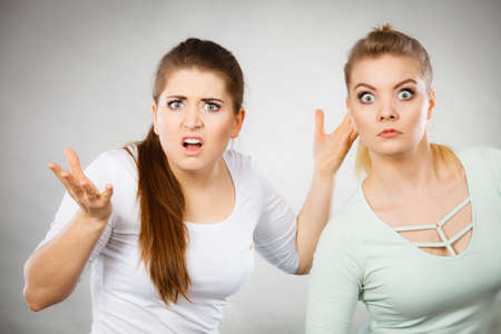 Shock face expressions concept. Closeup of two shocked and amazed women seeing something weird.