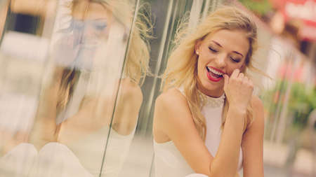 Glamurous female fashion model presenting casual elegant outfit. Woman wearing crop top and skirt. Summer urban look, outdoor photo session.の写真素材